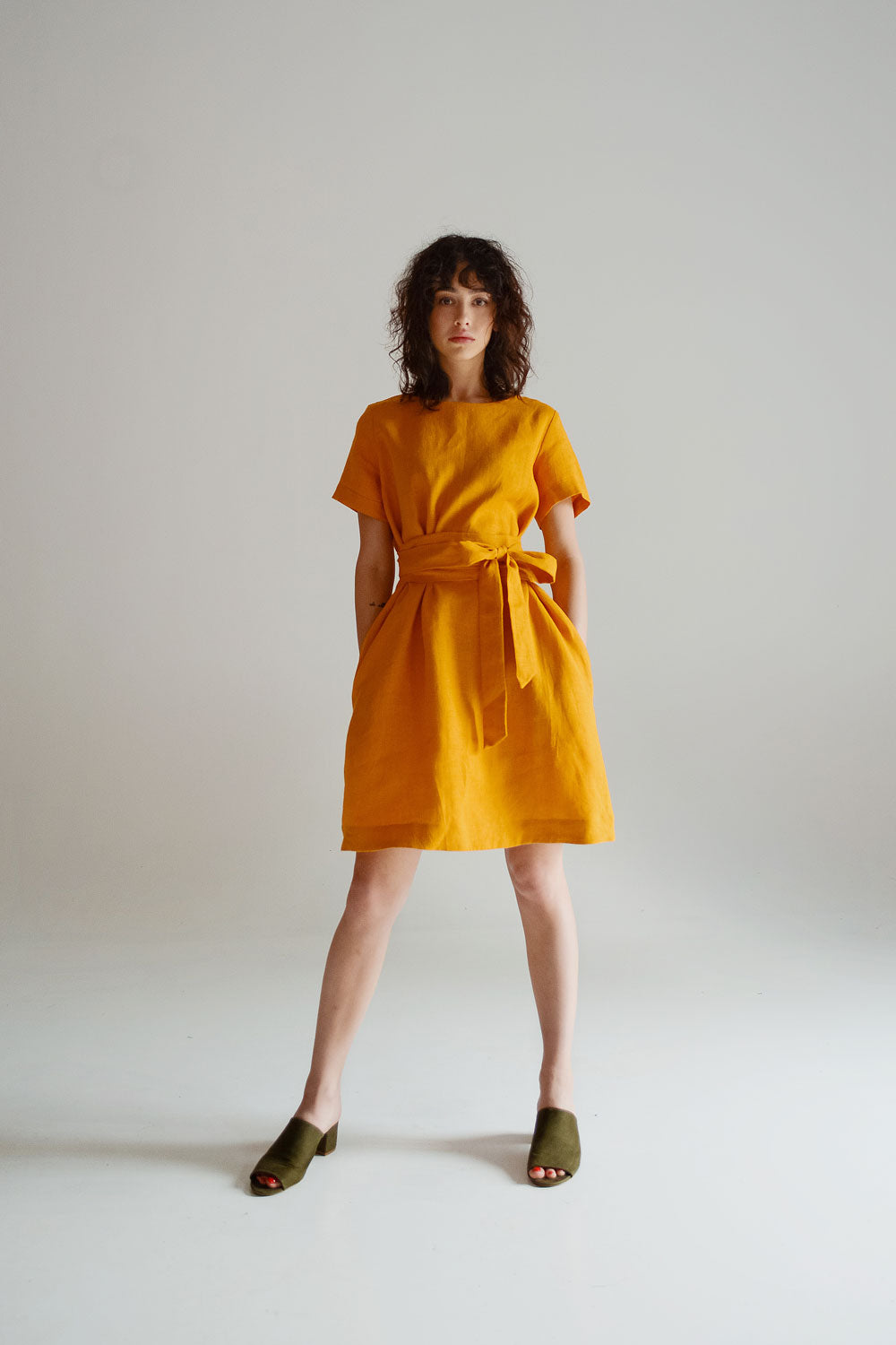 a woman in a yellow dress poses for a picture